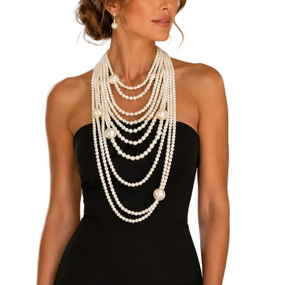 Woman in a black evening gown with pearl necklace in an elegant room.