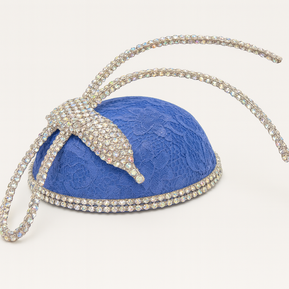 Blue lace handbag with a decorative bow and chain strap on a white background