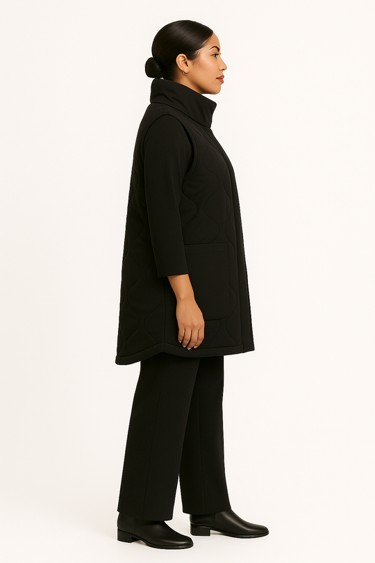 Woman wearing a black coat and pants on a white background