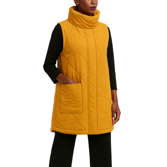 Woman wearing a yellow quilted vest over a black top on a white background