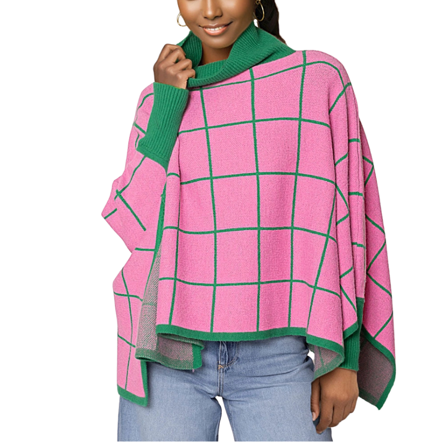 A woman wearing a pink and green plaid cowl neck poncho over a blue outfit.