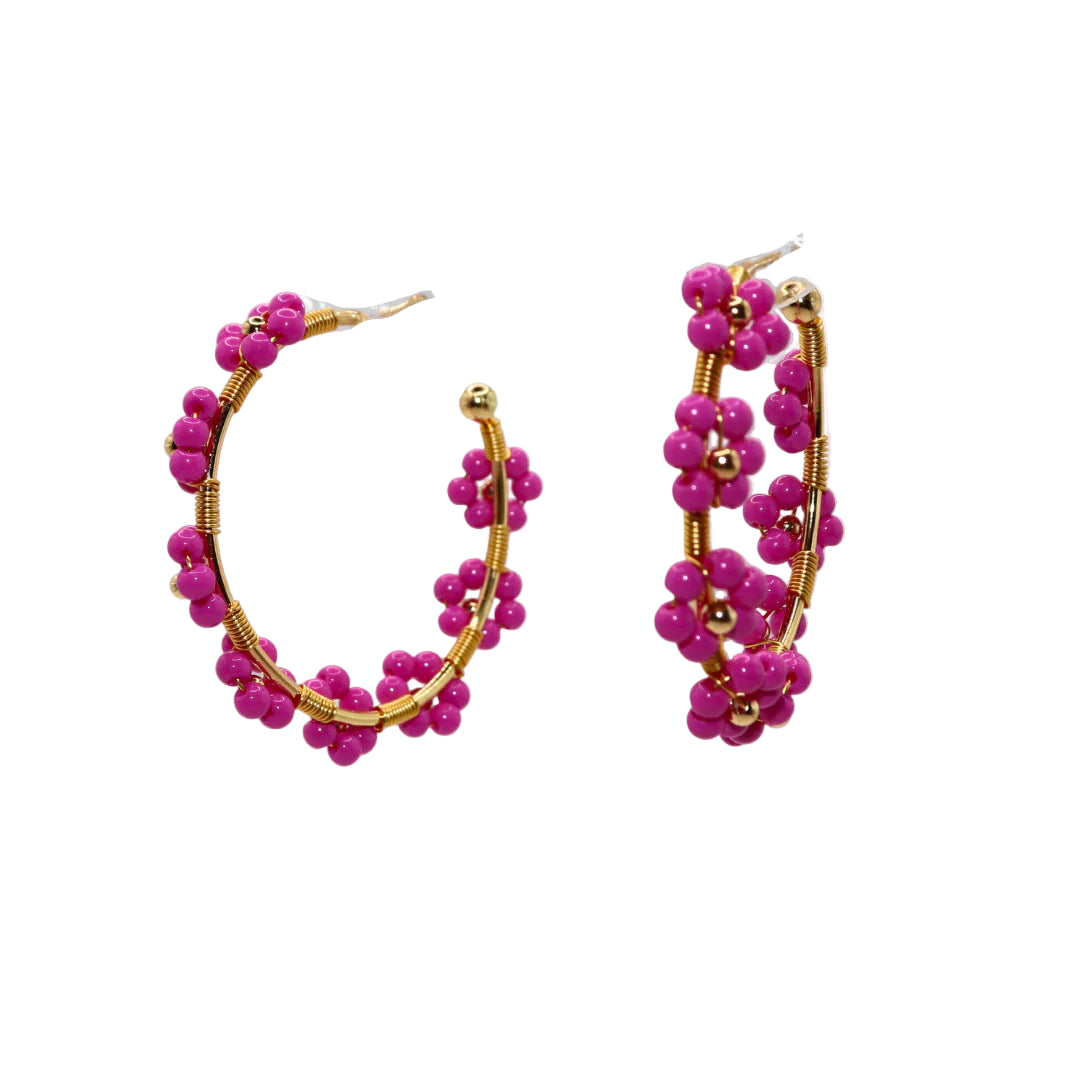 Pair of pink beaded hoop earrings with gold accents on a white background