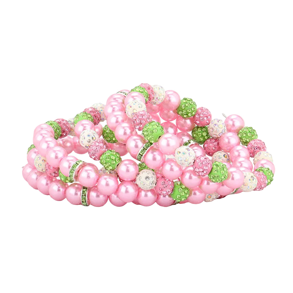 Pink and green beaded slide sandals on a white background