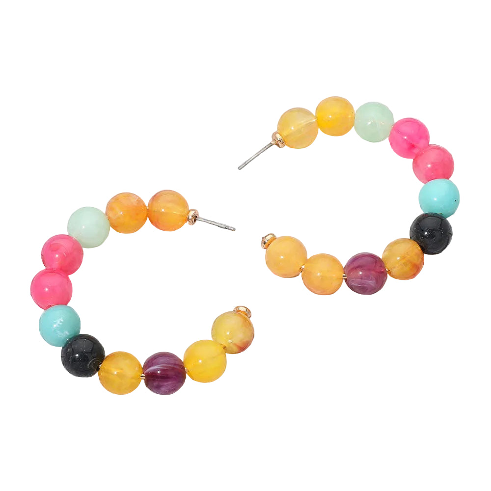 A pair of beaded hoop earrings with multicolor round beads in pink, orange, yellow, turquoise, black, purple, and mint green, displayed on a white wood plank background.