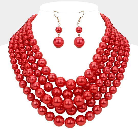 Red pearl necklace and earrings set on a mannequin with a white background