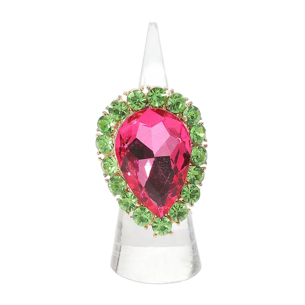 Jewelry ring with a pink teardrop gem and green gemstones on a white background