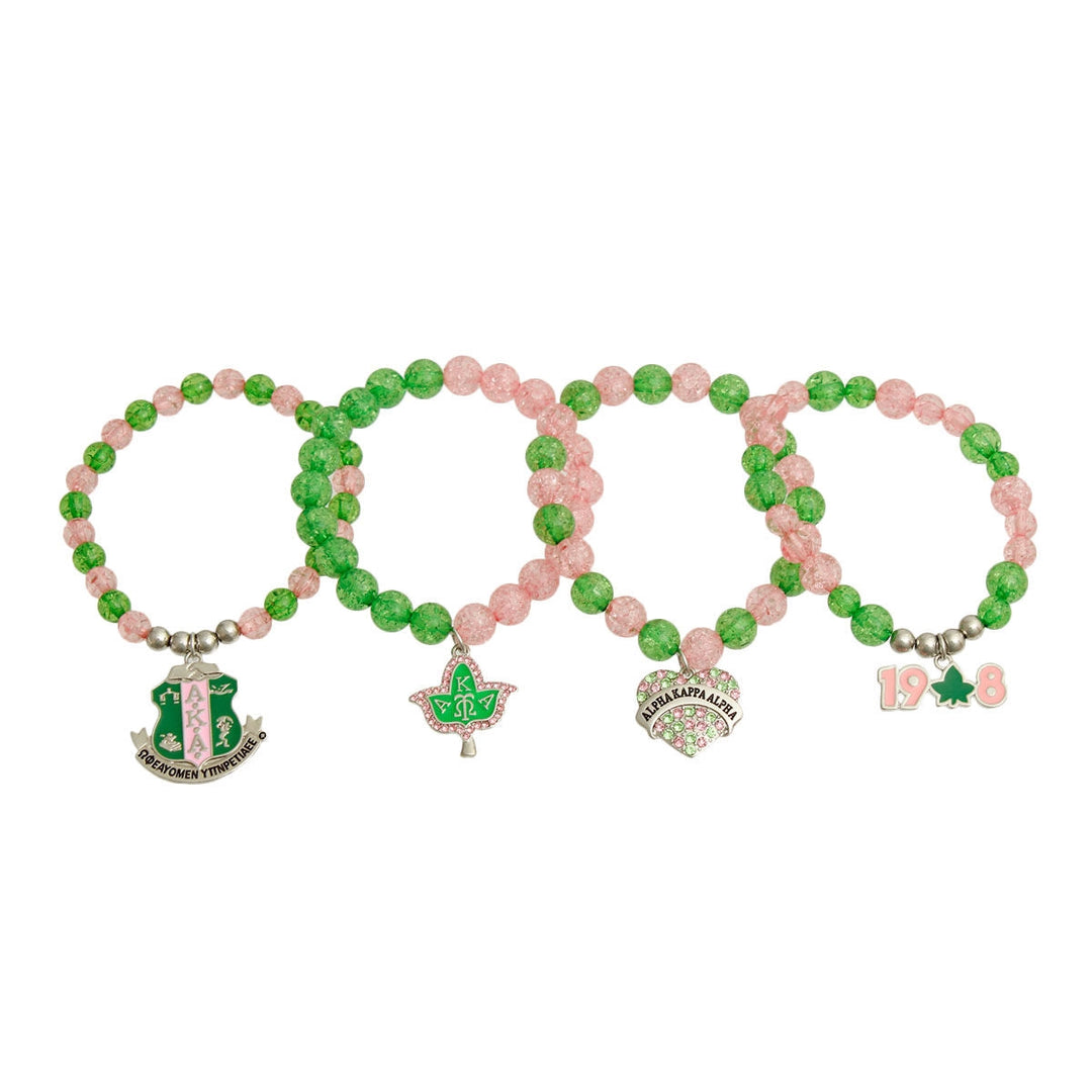 Set of four beaded bracelets with charms on a white background