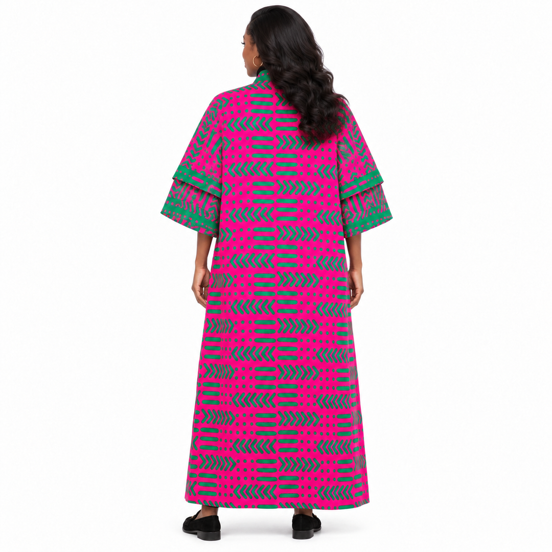A woman viewed from the back wearing a long kaftan dress with a vibrant pink and green geometric pattern and layered elbow-length sleeves, set against a plain white background.