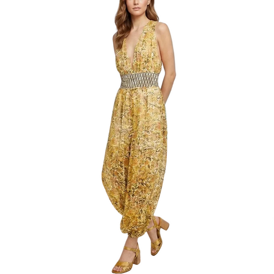 Woman in a yellow dress standing on a patio with ocean view