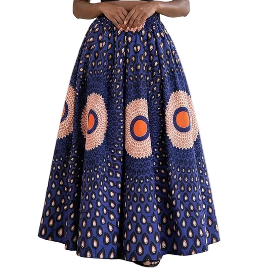 Woman wearing a black top and blue patterned skirt with orange circles indoors.