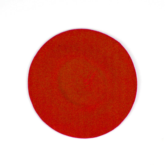 A circular red textured swatch on a plain white background.
