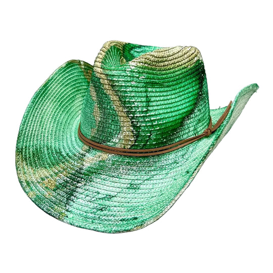 A green and gold patterned woven straw cowboy hat with a brown leather band, displayed on a textured gray concrete surface.
