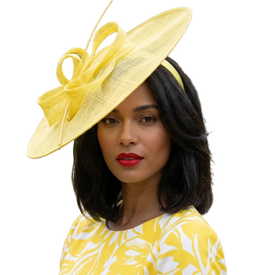 Woman wearing a yellow hat and dress with a blurred green background