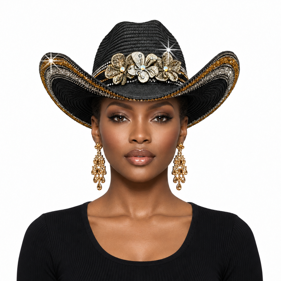 A woman wearing a black woven cowboy hat embellished with gold and silver floral decorations and rhinestone-like accents, paired with dangling gold earrings and a black top, against a plain white background.