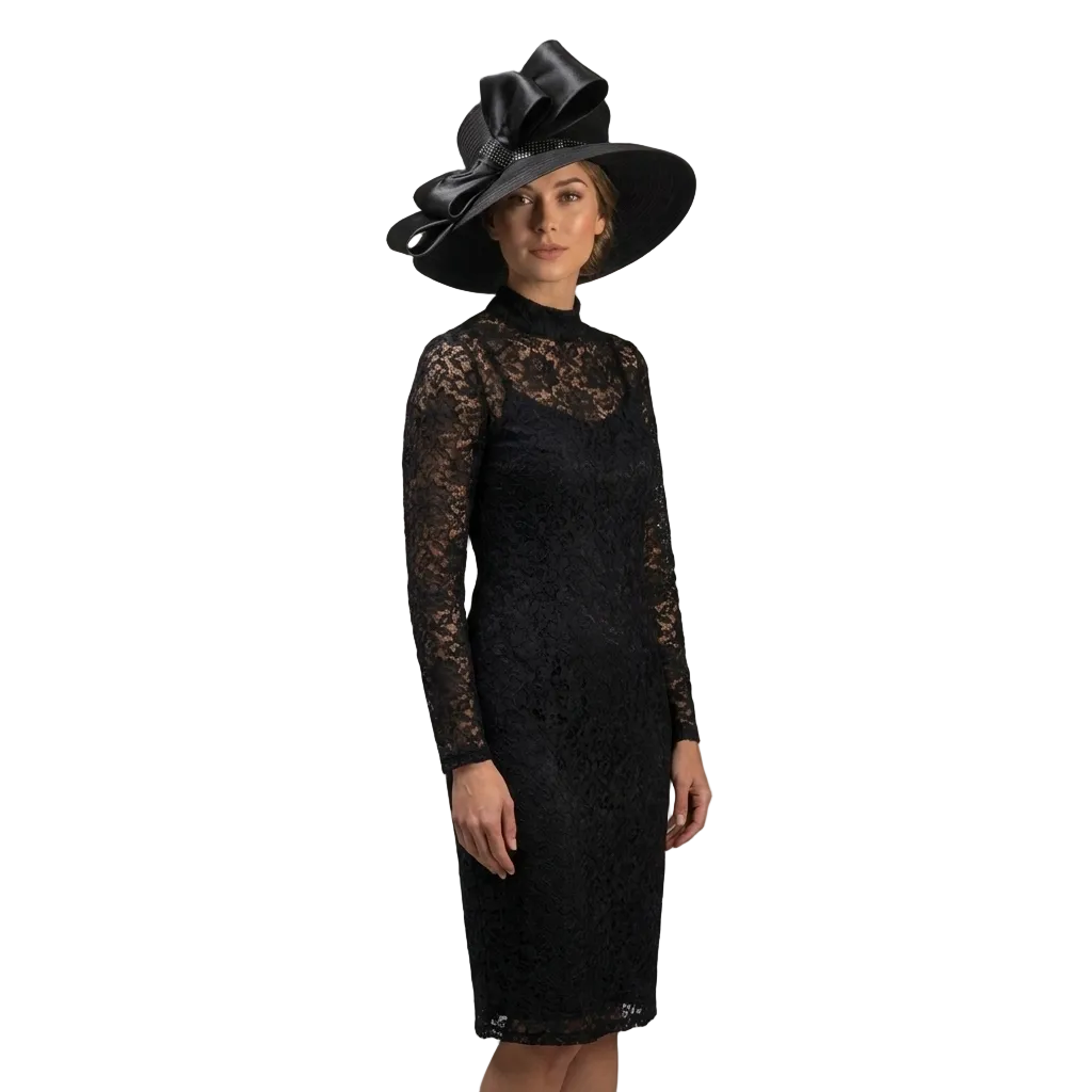 Woman wearing a black lace dress and matching hat against a gray background