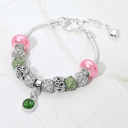 Silver bracelet with pink and green beads on a white background