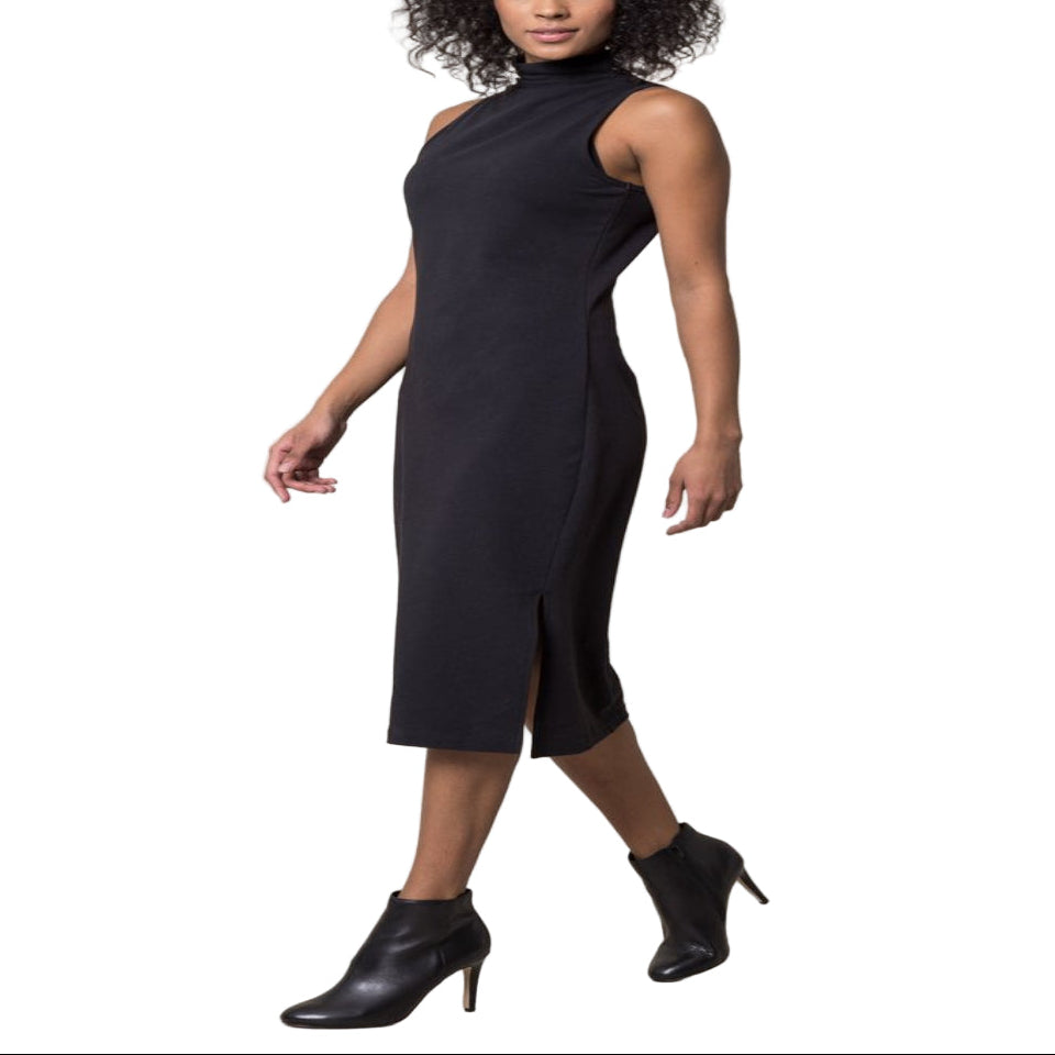 Woman wearing a black sleeveless dress with a slit on a beige background