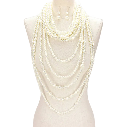 Multiple layers of pearl necklaces on a mannequin against a white background