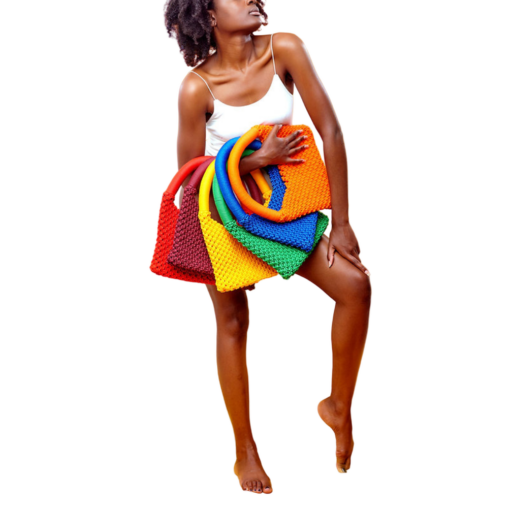 A person standing on one leg wearing a multicolored macrame baguette bag with rope handles.