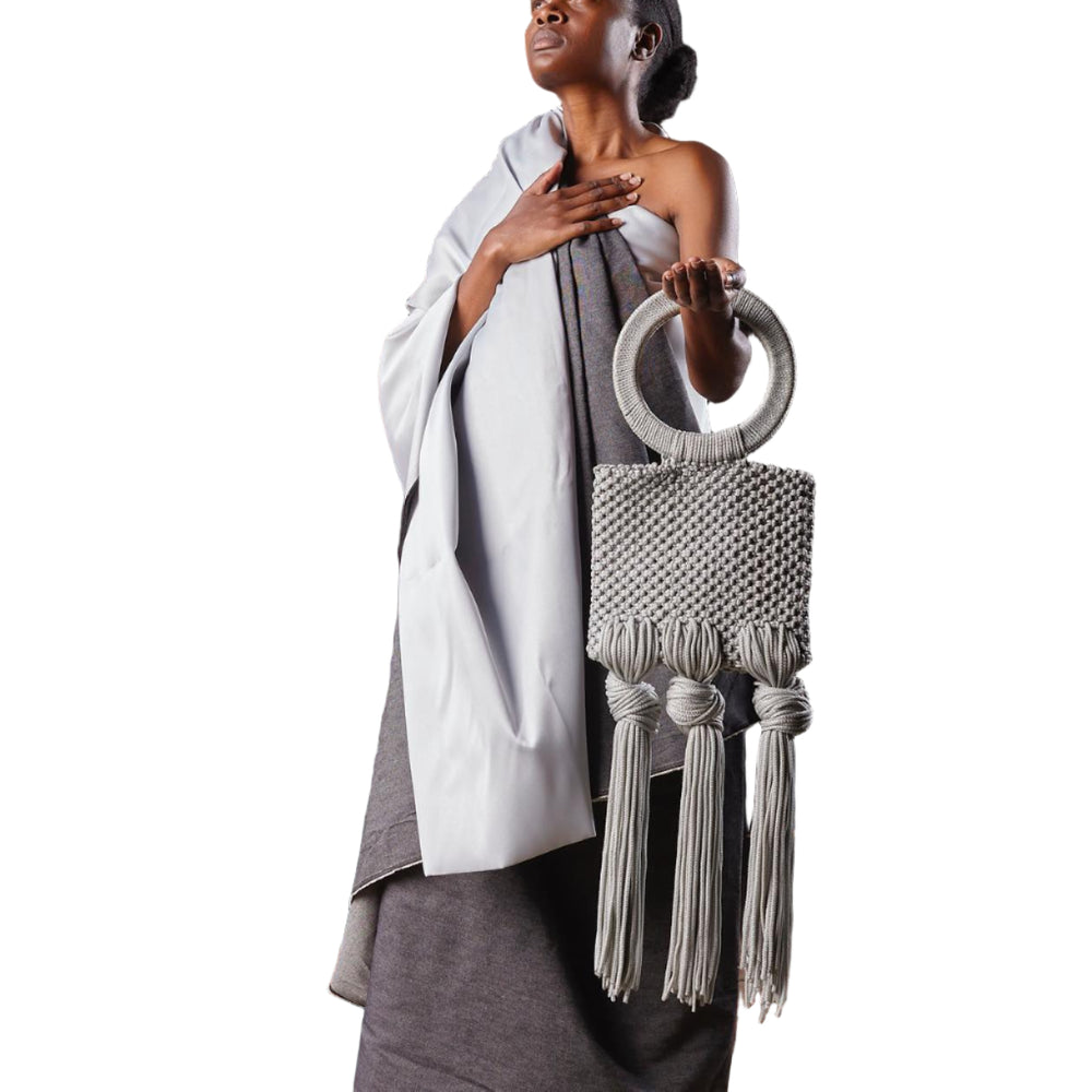 Woman holding a decorative bag against a dark background