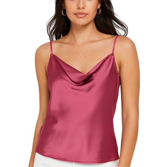 Woman wearing a pink satin camisole against a white background