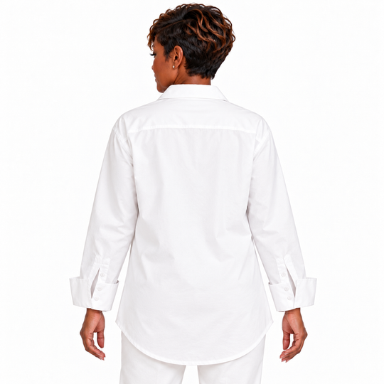 A woman shown from the back wearing a white long-sleeve button-up shirt and matching white pants against a plain white studio background.