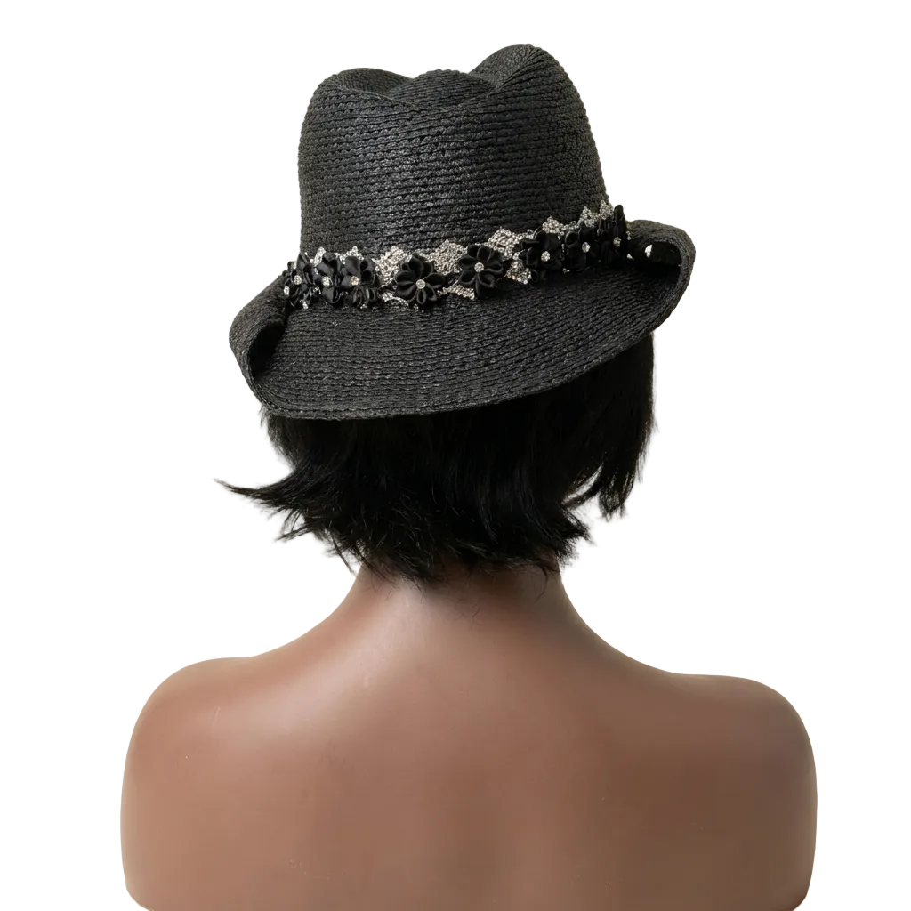 Black straw hat with decorative band on a mannequin head against a beige background
