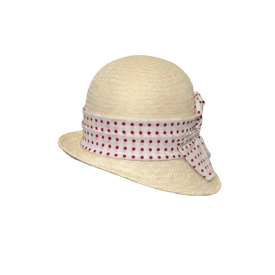 Beige straw hat with a polka dot band on a beige background