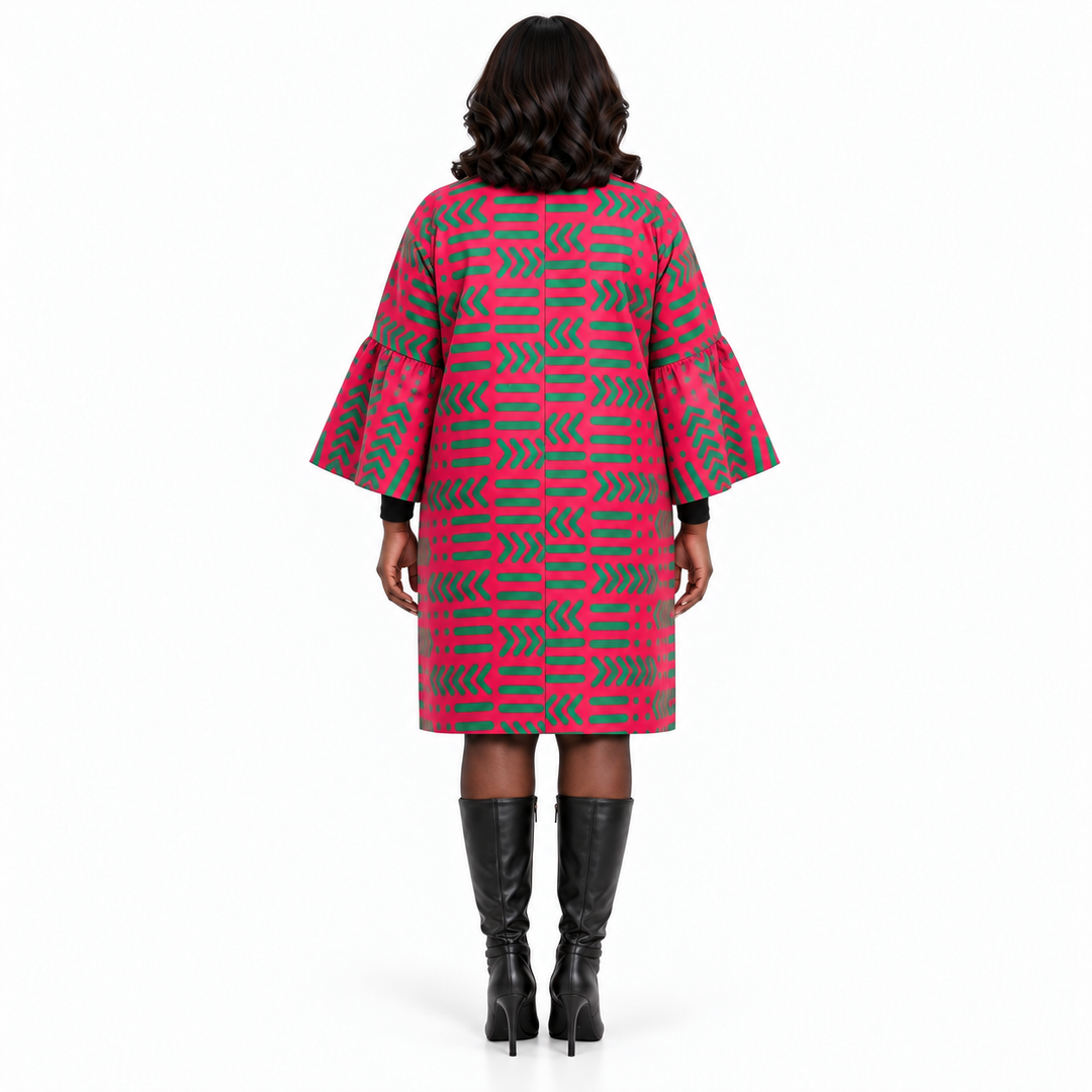 A woman viewed from the back wearing a pink and gray geometric patterned coat with flared sleeves, paired with black knee-high boots, against a plain white background.