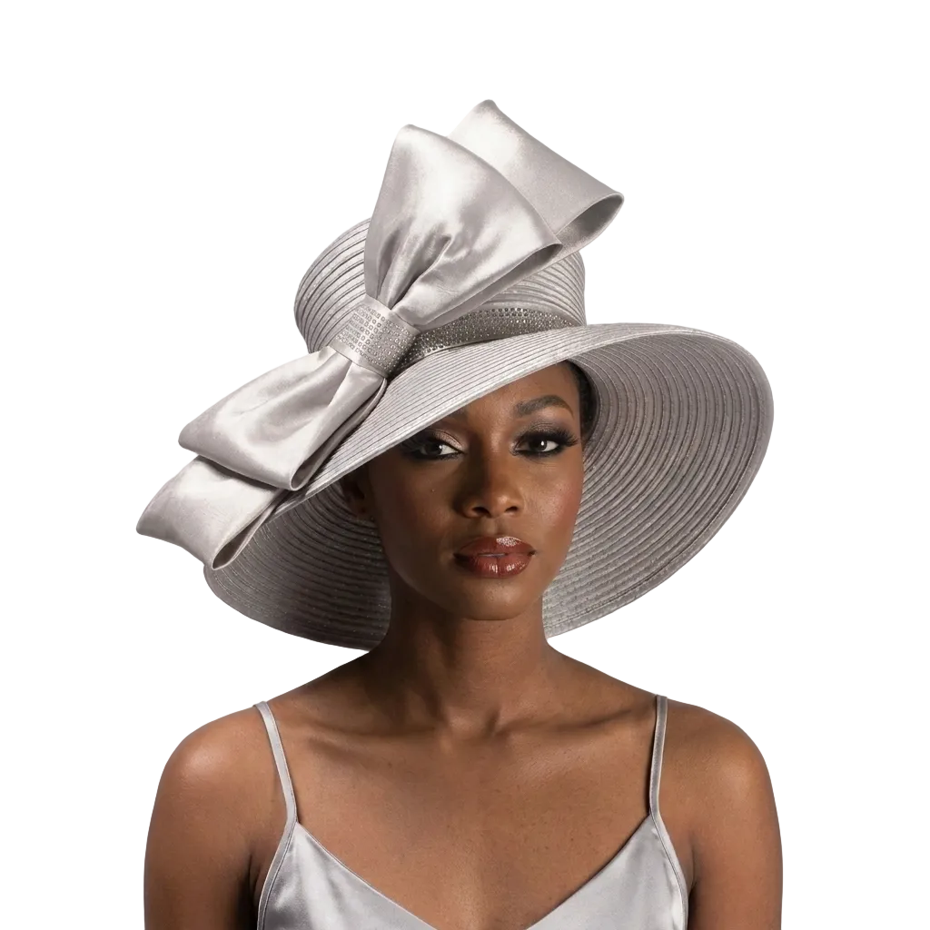 Woman wearing a large silver hat with a bow on a gray background