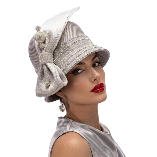 Woman wearing a decorative silver hat with a white bow on a white background