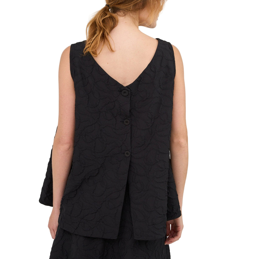 Woman wearing a black sleeveless top and skirt set on a white background