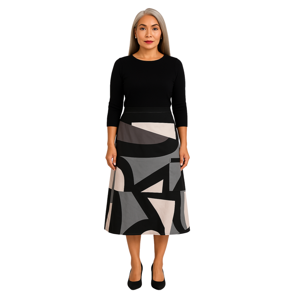 Woman wearing a black top and patterned skirt on a white background