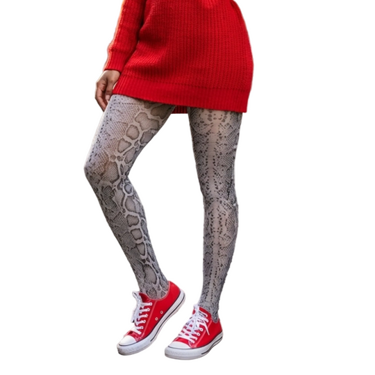 Person wearing red sweater, patterned leggings, and red sneakers on a street.