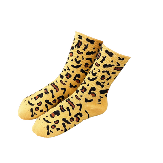 Yellow leopard print socks worn by a person sitting on a black chair.