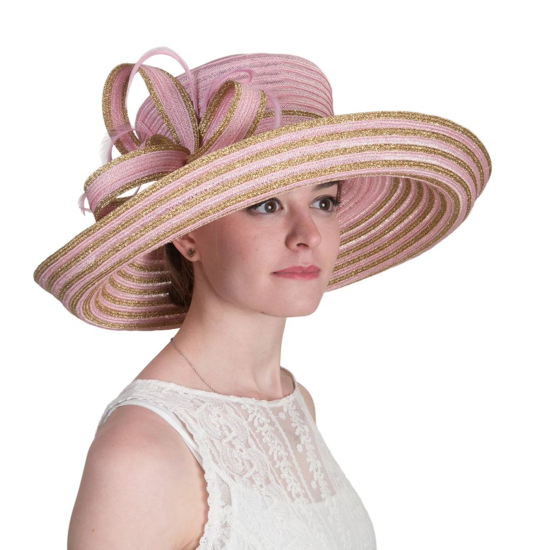 Woman wearing a large pink and gold hat against a white background