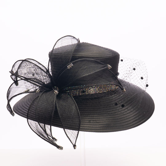 Black decorative hat with netting and embellishments on a white background