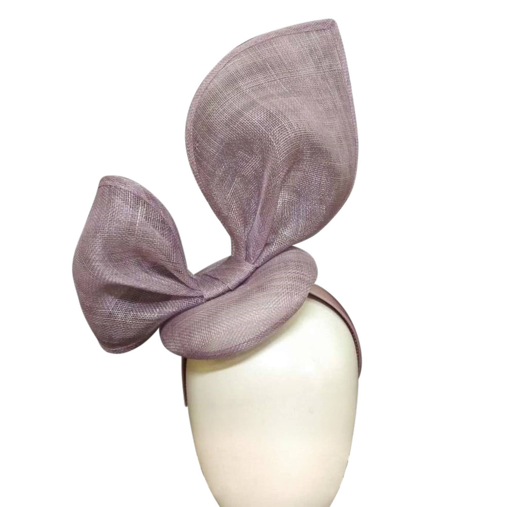 A lavender-colored, bunny ear inspired, sinamay headband on a mannequin head.