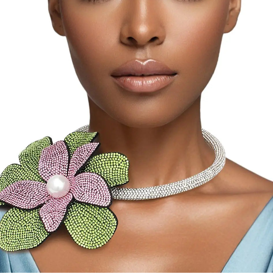 Woman wearing a decorative necklace with a floral design and pearl center.