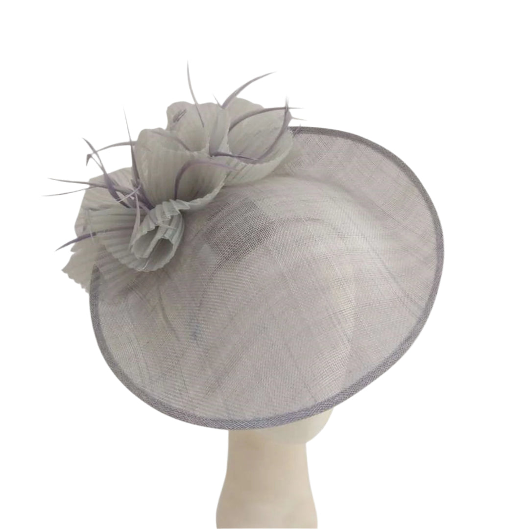 Large decorative hat with floral detail on a mannequin head against a white background