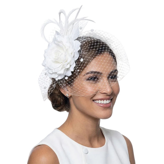 Woman wearing a white floral headpiece with a veil on a white background