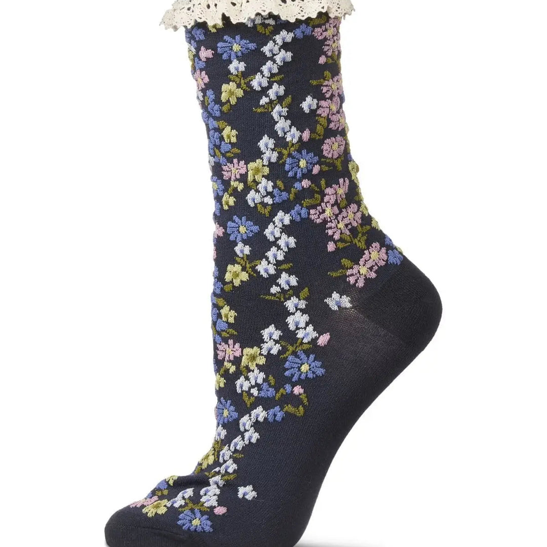 A single dark navy crew sock with a delicate white floral pattern and a white lace ruffle at the top cuff, shown against a plain white background.