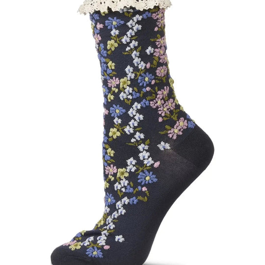 A single dark navy crew sock with a delicate white floral pattern and a white lace ruffle at the top cuff, shown against a plain white background.