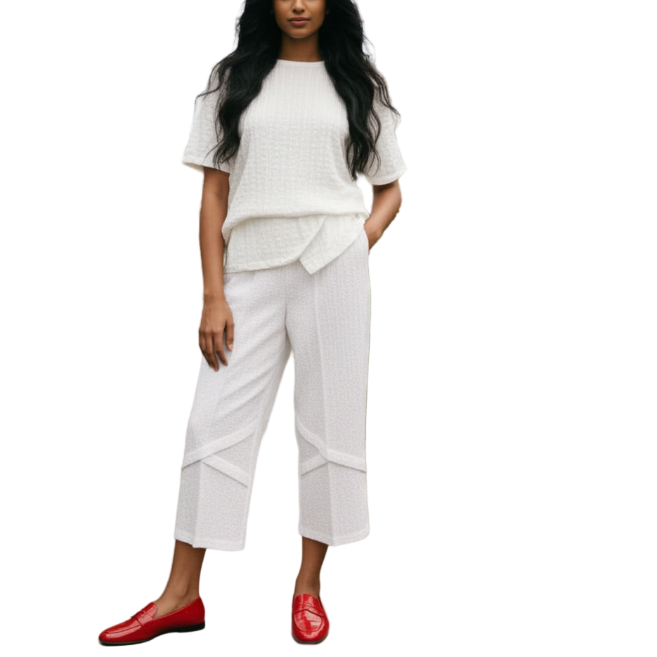 Woman in a white outfit with red shoes standing in a greenhouse