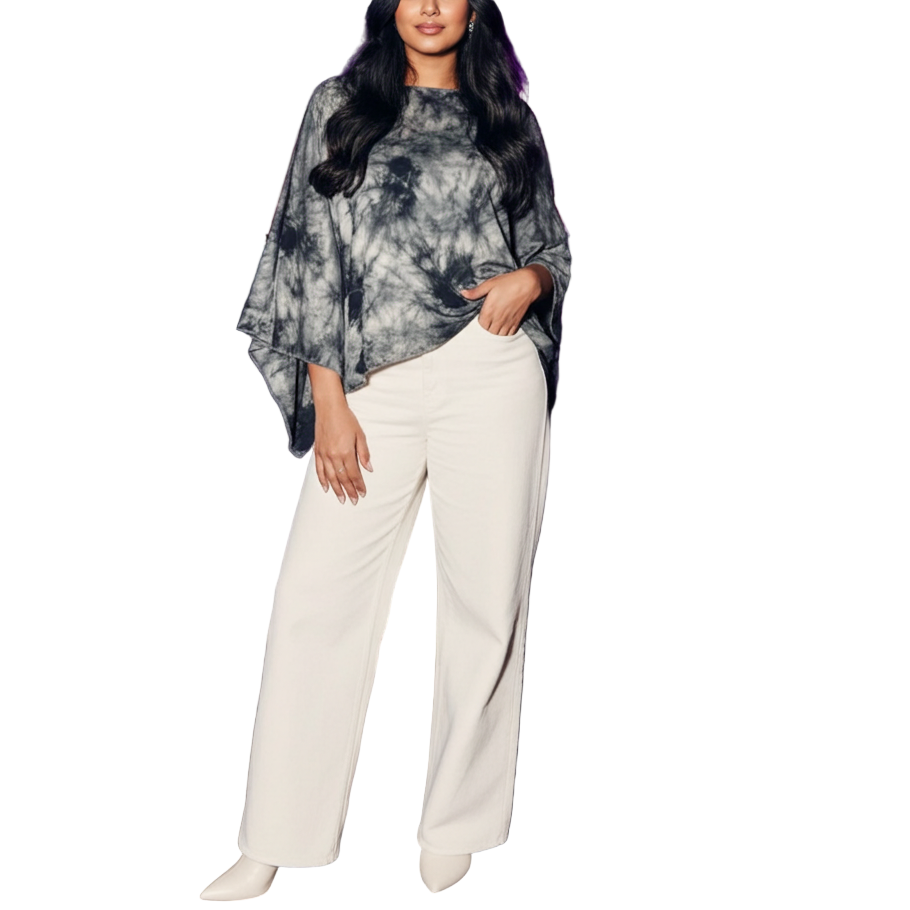 Woman in a tie-dye top and white pants standing in an indoor event space with purple lighting.