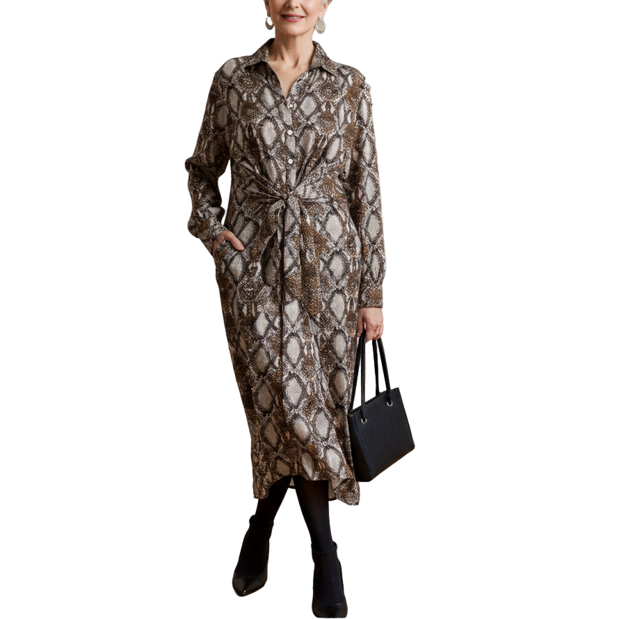 Woman in a patterned dress standing in an art gallery with framed artwork on the walls.