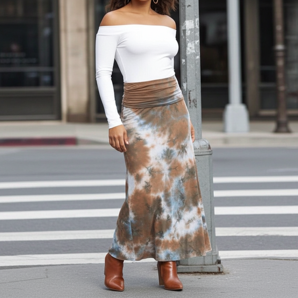 Person wearing a white top and tie-dye skirt on a city street.