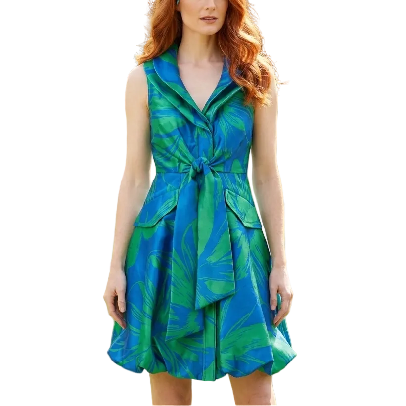 Woman wearing a blue and green dress with a floral headpiece in a garden setting