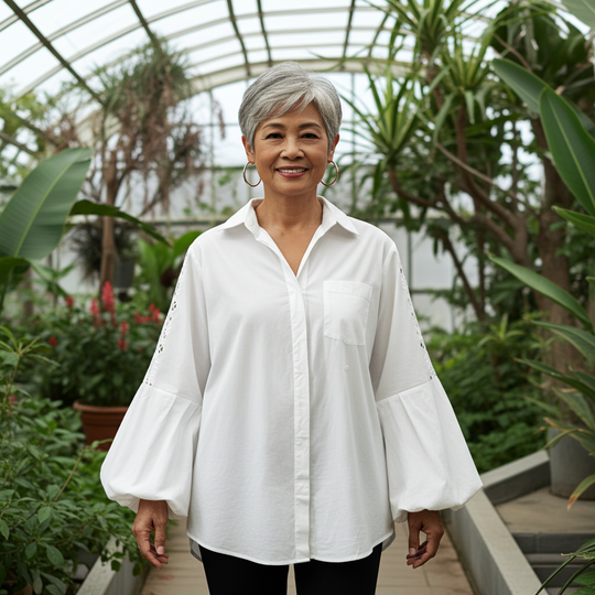 Woman in a white shirt standing in a greenhouse filled with plants
