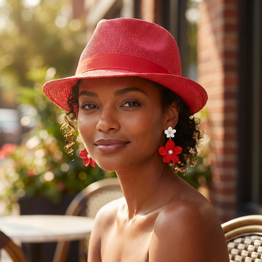 Woman wearing a red hat and earrings in an outdoor setting